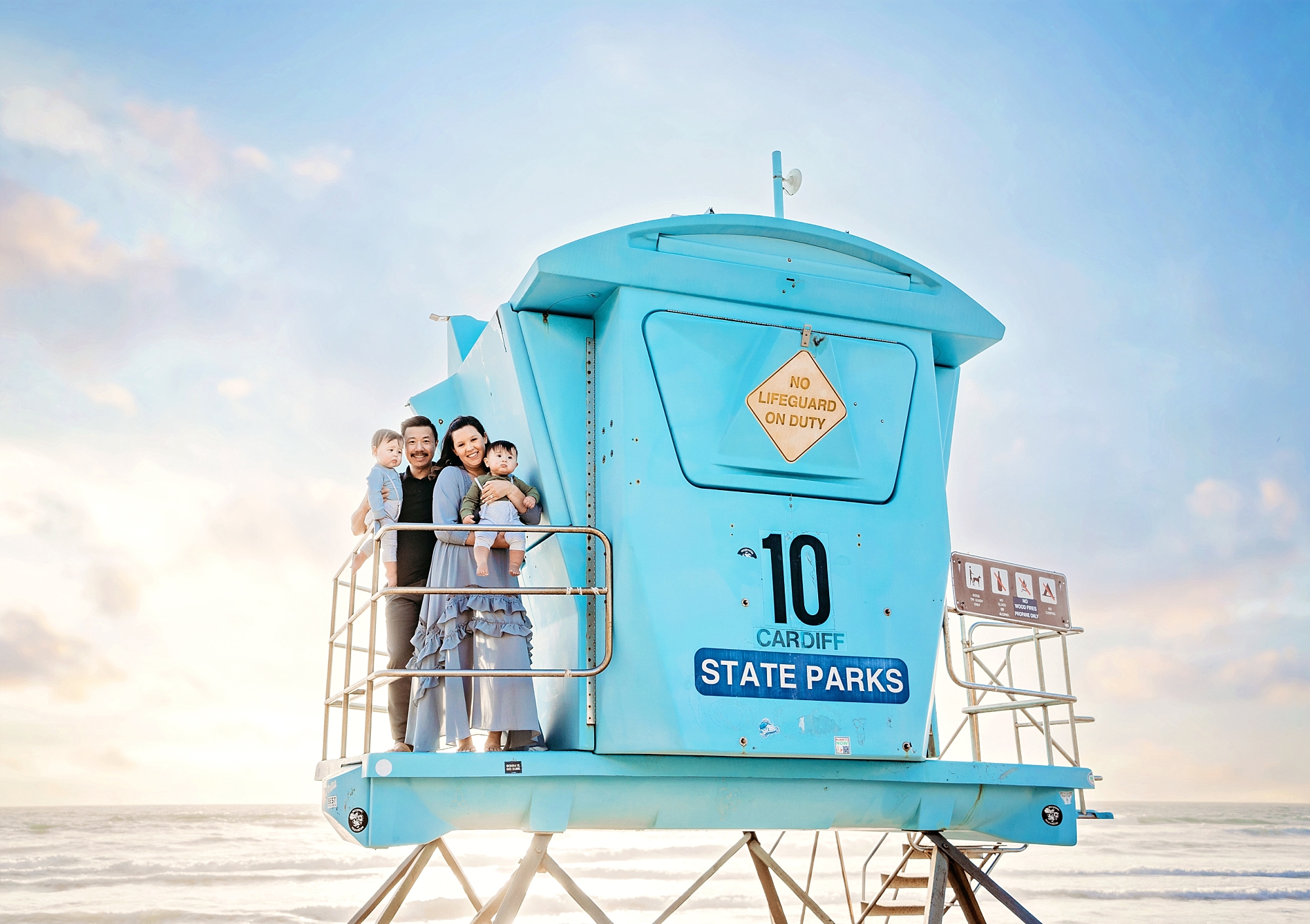family portraits on lifeguard stand at california beach