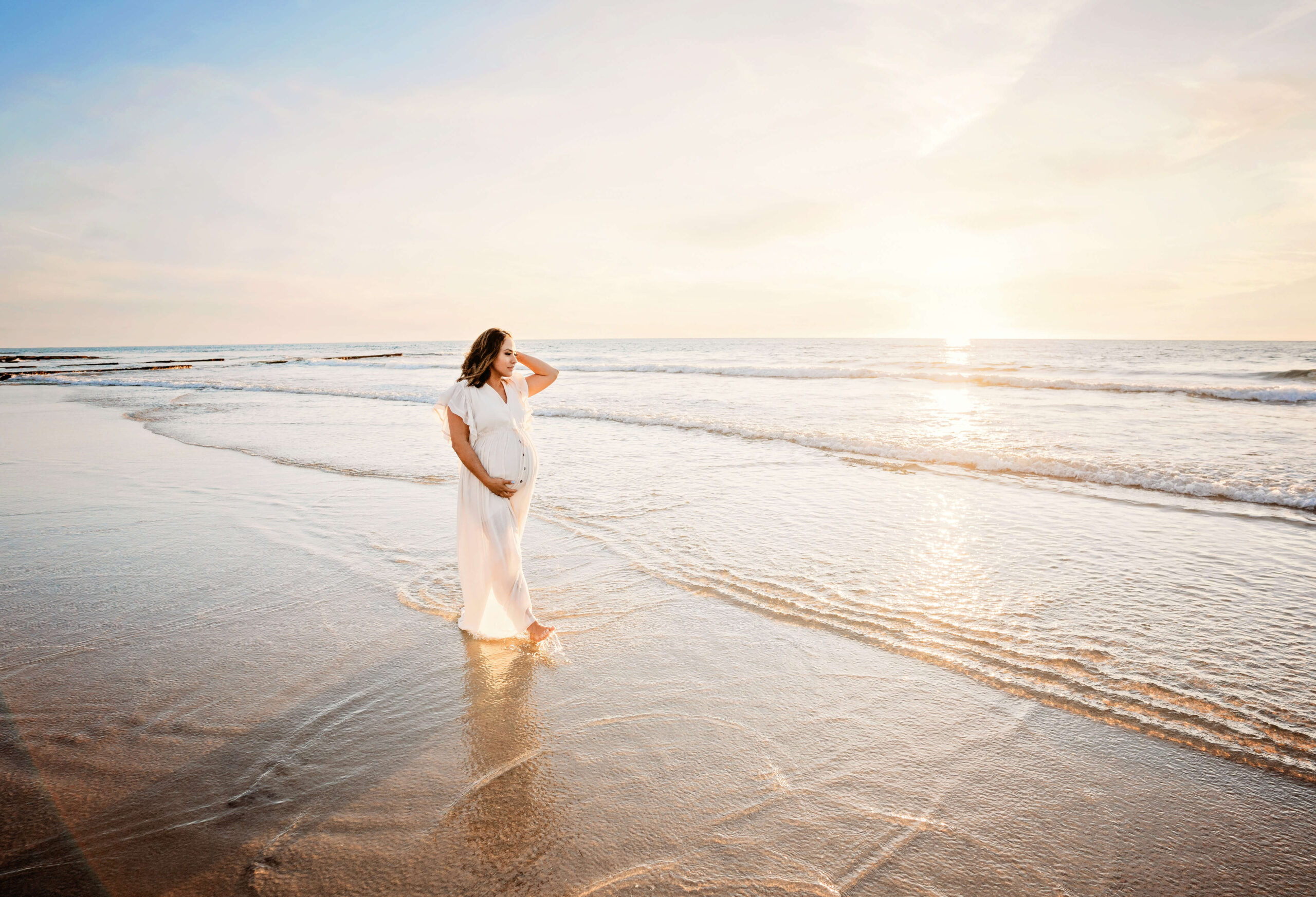 Gorgeous expecting mother walking on the beach during her session with San Diego pregnancy photographer, Tristan Quigley