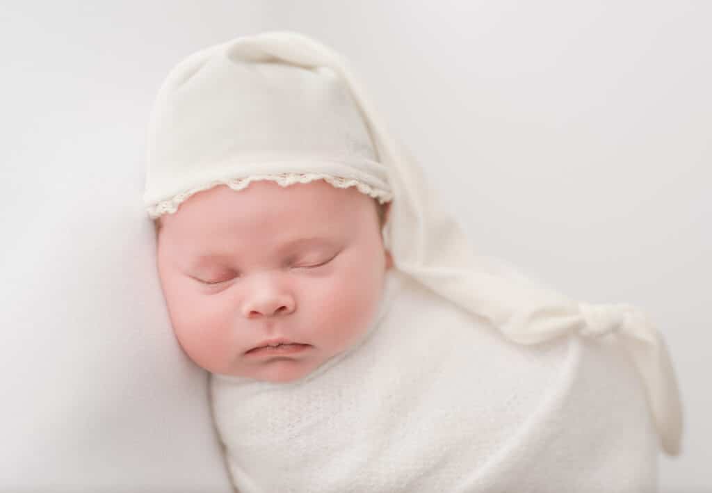 Finding The Best Carlsbad Newborn Photographer Starts with These 3 Questions 3 Newborn baby girl sleeping during her session with Carlsbad newborn photographer, Tristan Quigley with swaddle