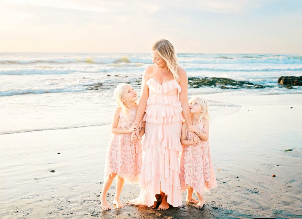 What to Wear for Spring Family Photos: The Perfect Outfits 3 mom & two daughters dressed beautifully for their spring family photos on the beach in encinitas