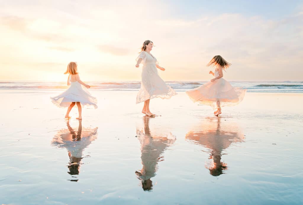 Mom and kids in flowy neutral dresses on a San Diego beach during a fall family photo session