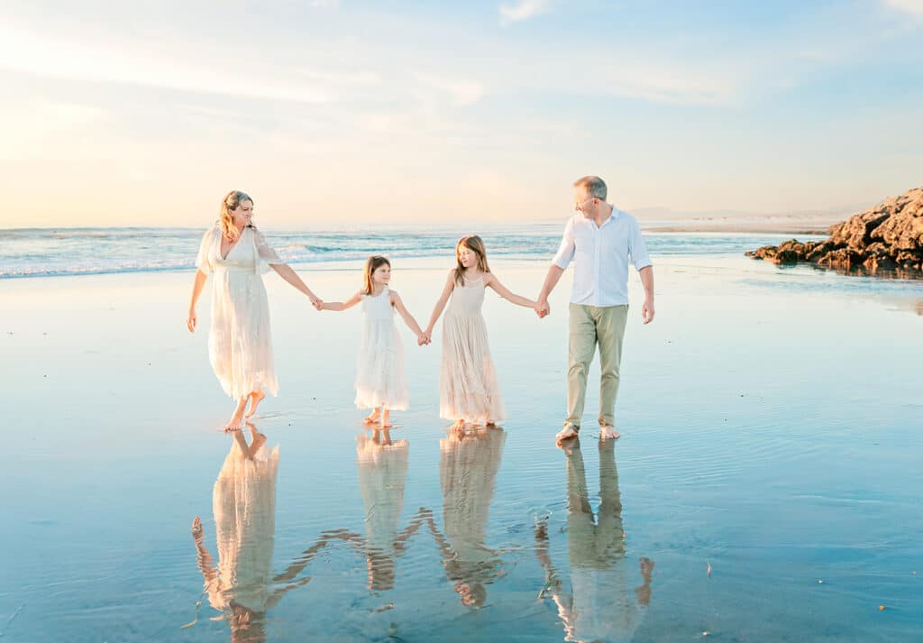 Family walking along the beach in San Diego, dressed in light neutral outfits for fall family photos
